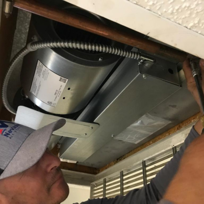 "Technician installing a new cooling system in a residential building, ensuring efficient and reliable air conditioning performance.