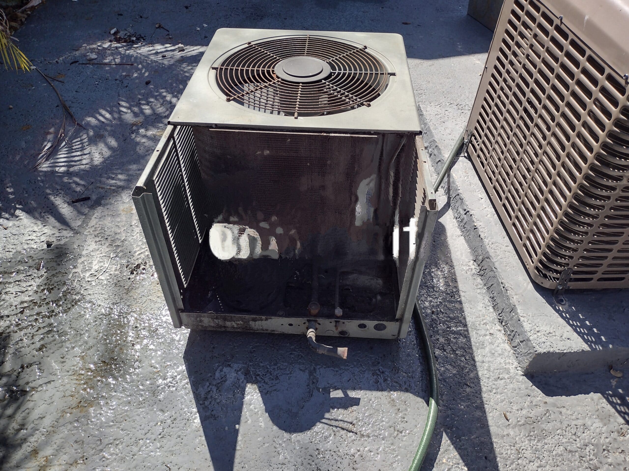 Central air conditioning system with visible dirt and debris, indicating the need for professional cleaning and repair to restore optimal performance